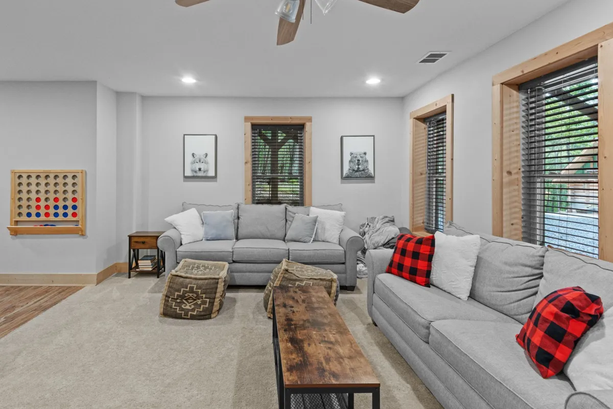 A comfortable room with sofas, decorative pillows, a coffee table, and a board game set up. Framed pictures on the wall add to the inviting, family-friendly atmosphere, perfect for game nights and casual gatherings.